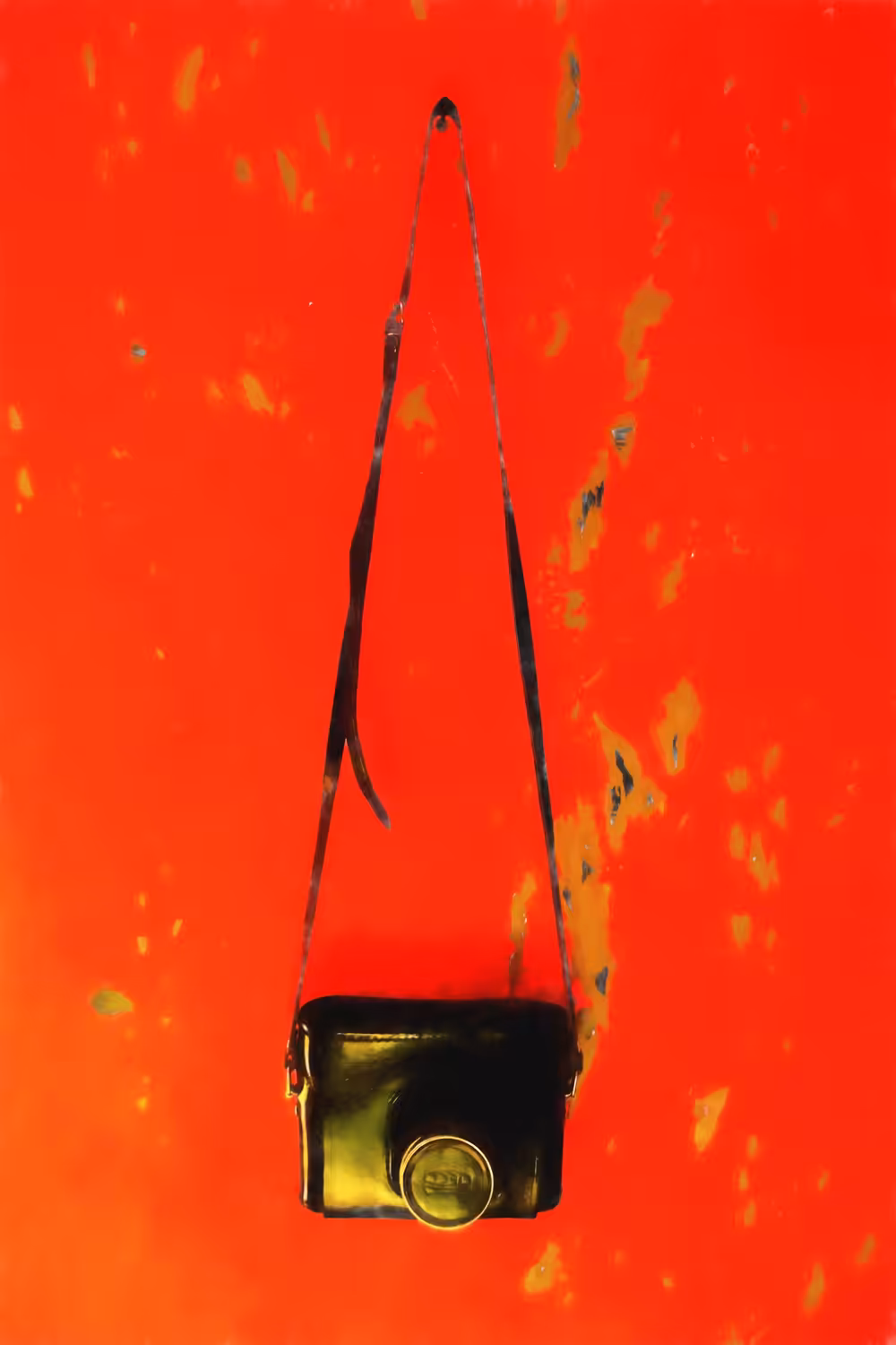 An old camera on a red wall