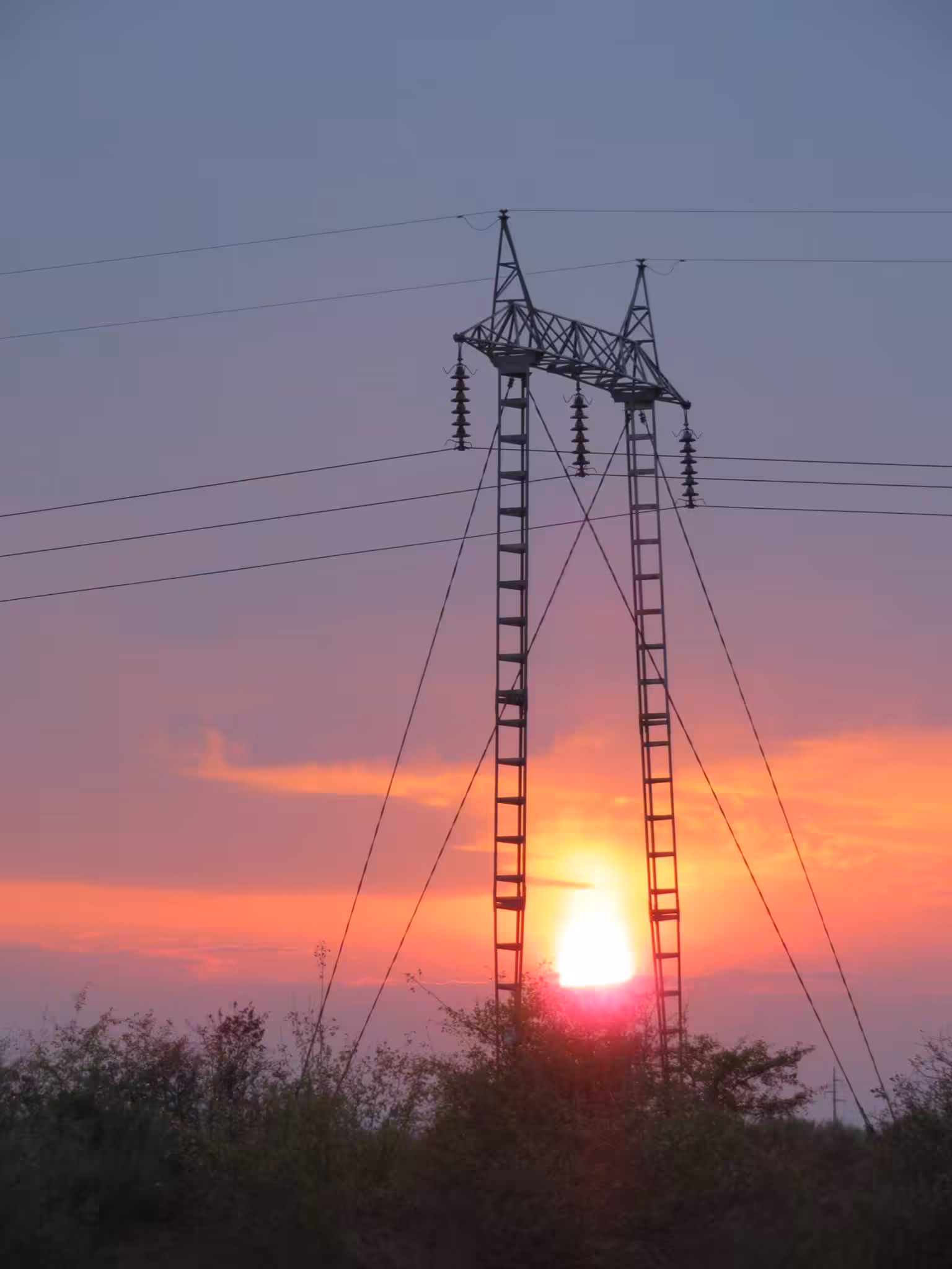 Sun setting between electrical tower