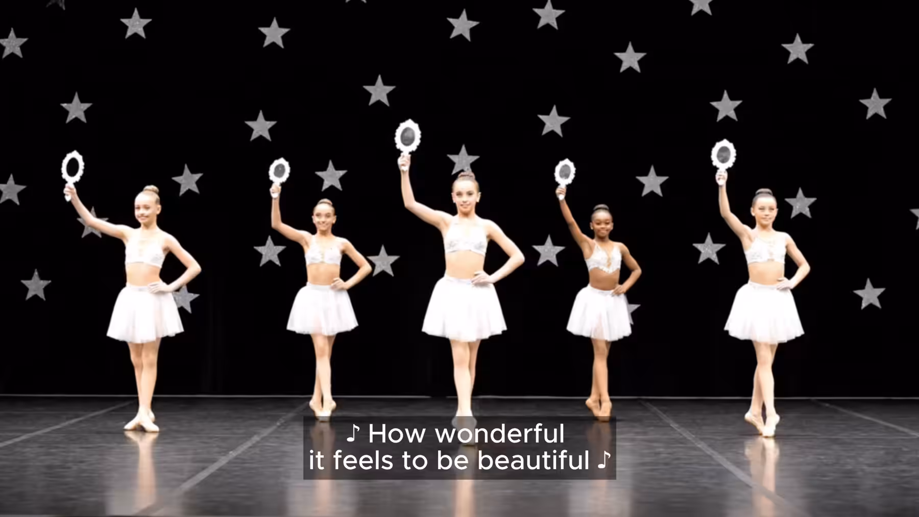Maya Man, StarQuest — synthetic dancers in white tutus holding hand-mirrors against a star-field, captioned How wonderful it feels to be beautiful