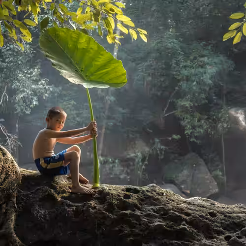 Child hiding under a green umbrella #1