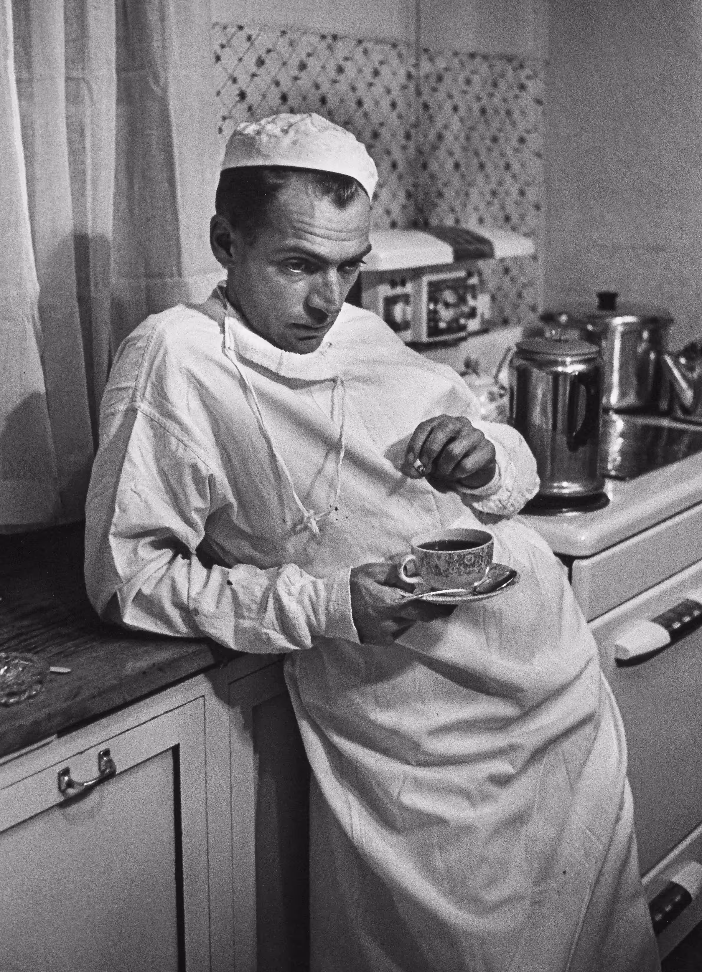 Country Doctor - Dr. Ernest Ceriani Holding Coffee Cup and Cigarette in Hospital Kitchen at 2:00 A.M. After Surgery