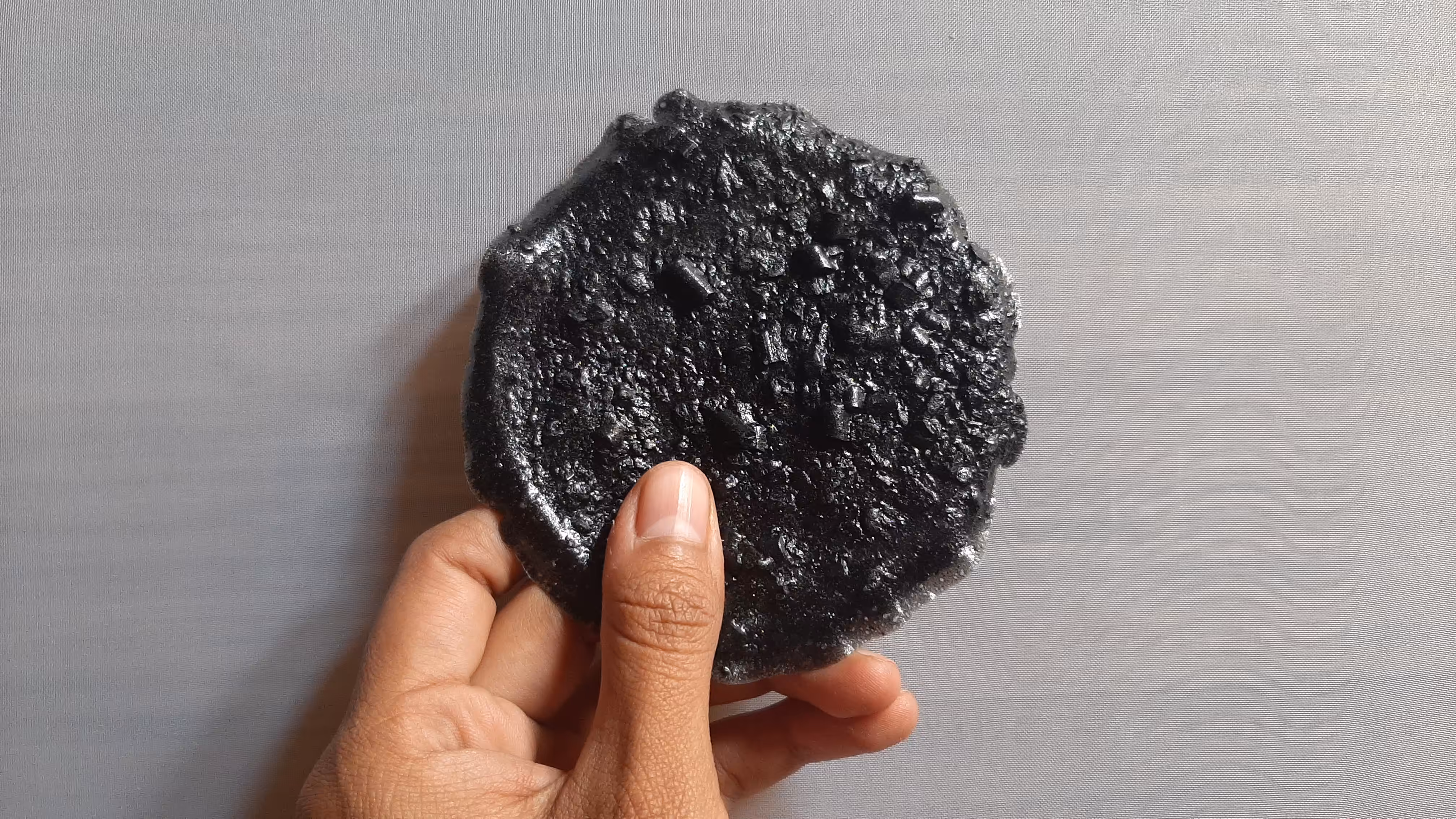 Circular shape, held in my hand, back view