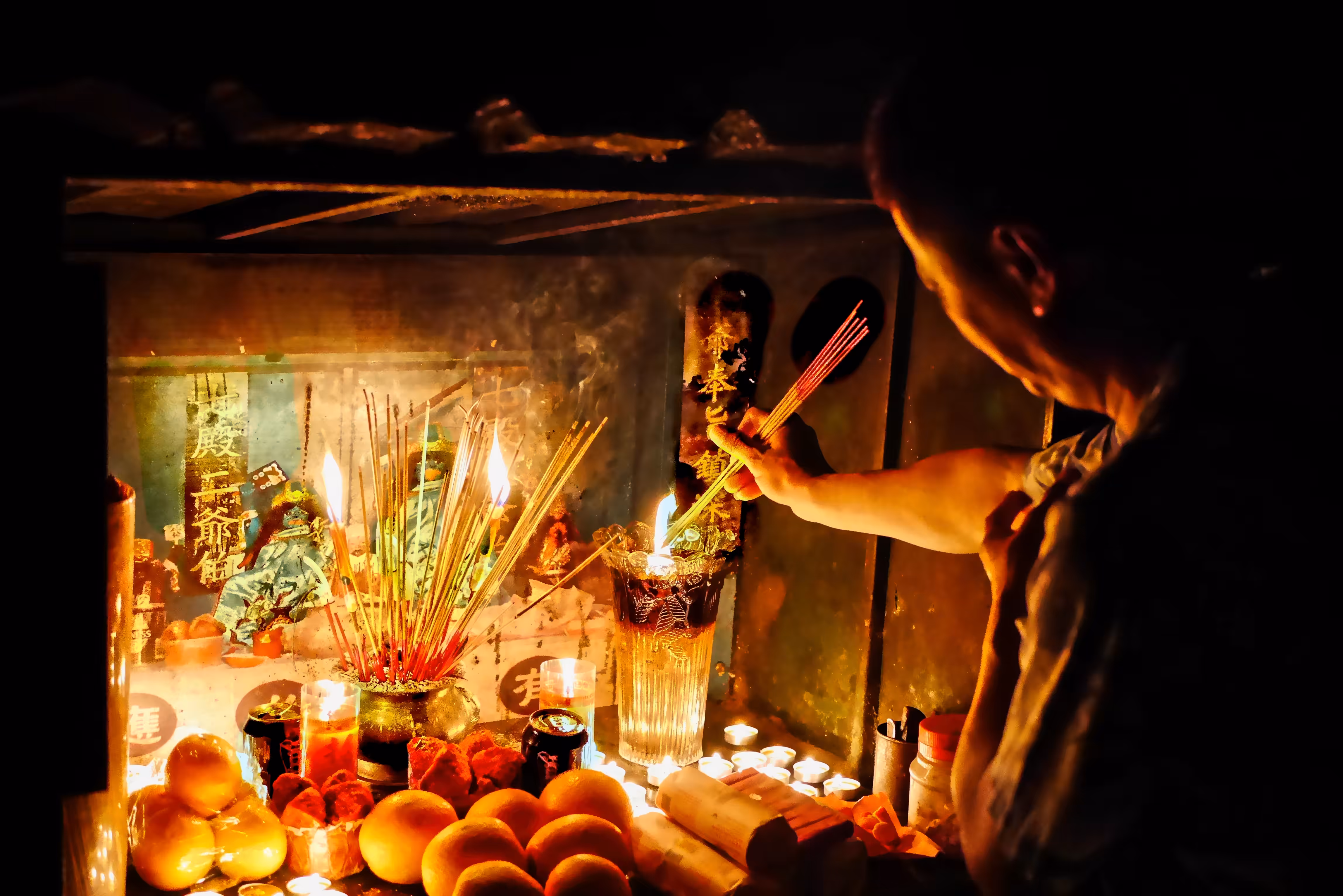 Night-time Cemetery Rituals, Singapore (9)  A spirit medium offering incense at a Hell deity altar
