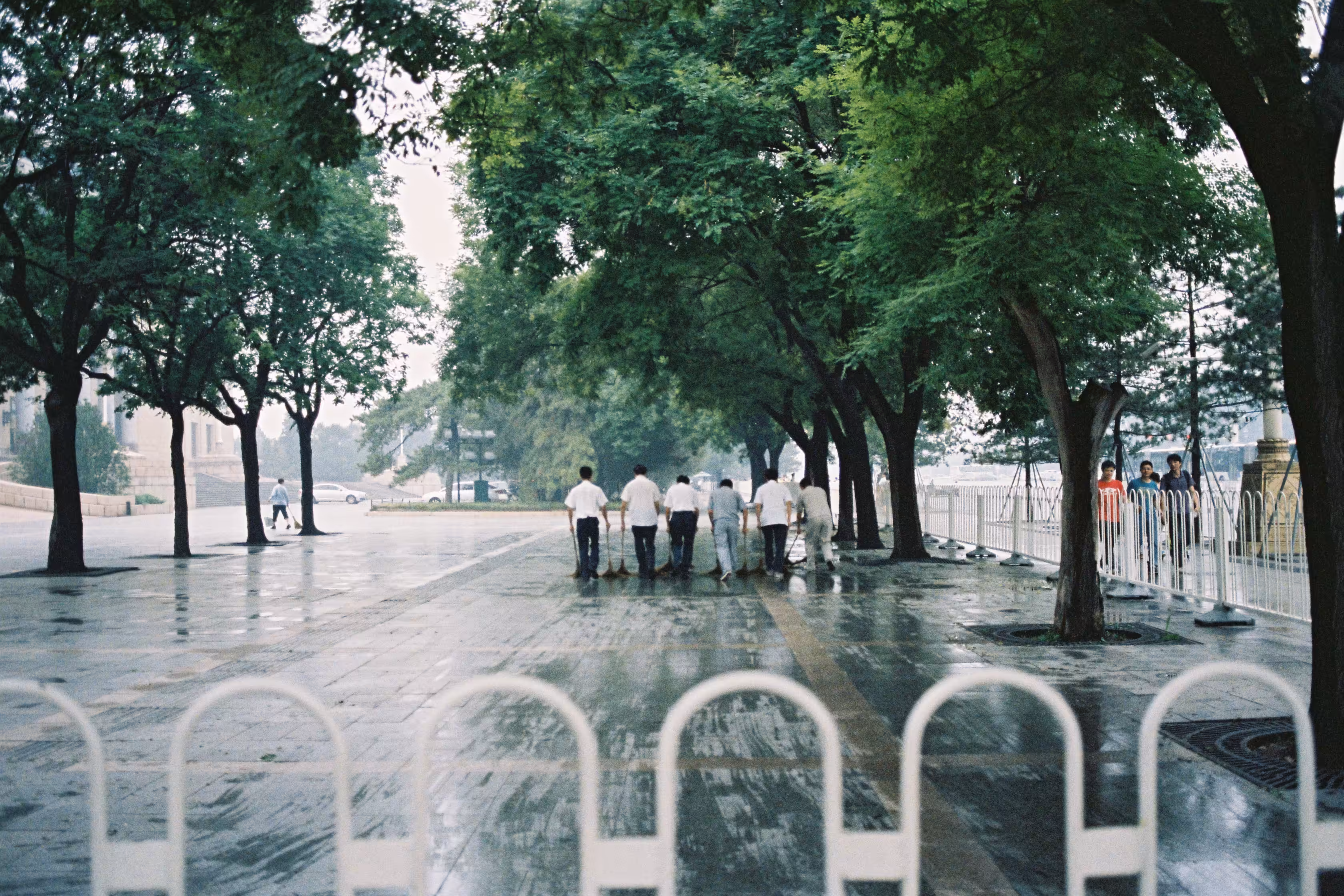 a line of elderly men cleaning tiananmen square